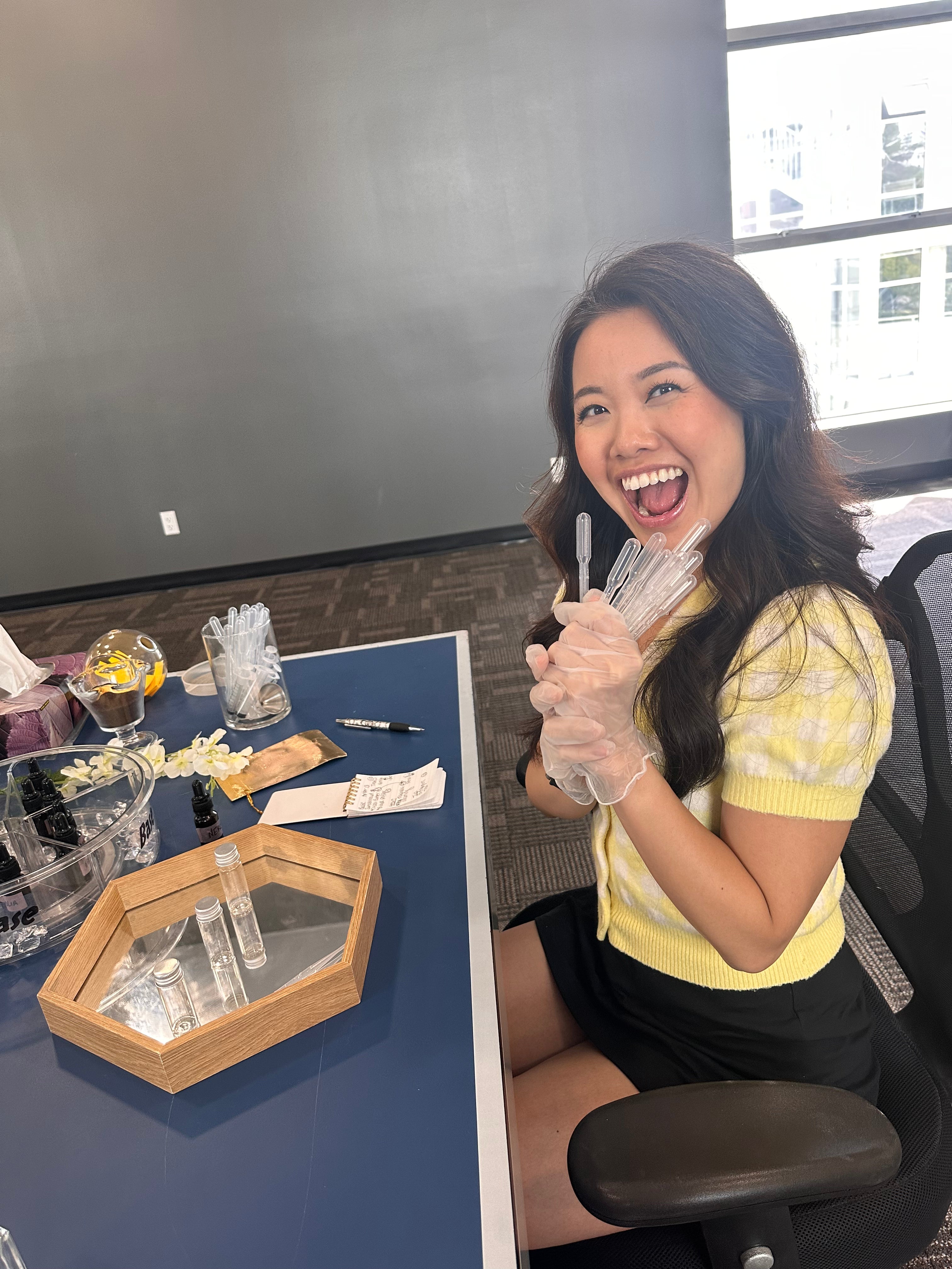 Fun classes in Vancouver: a laughing guest holding a handful of pipettes at an ARTEI PHIRE perfume making workshop