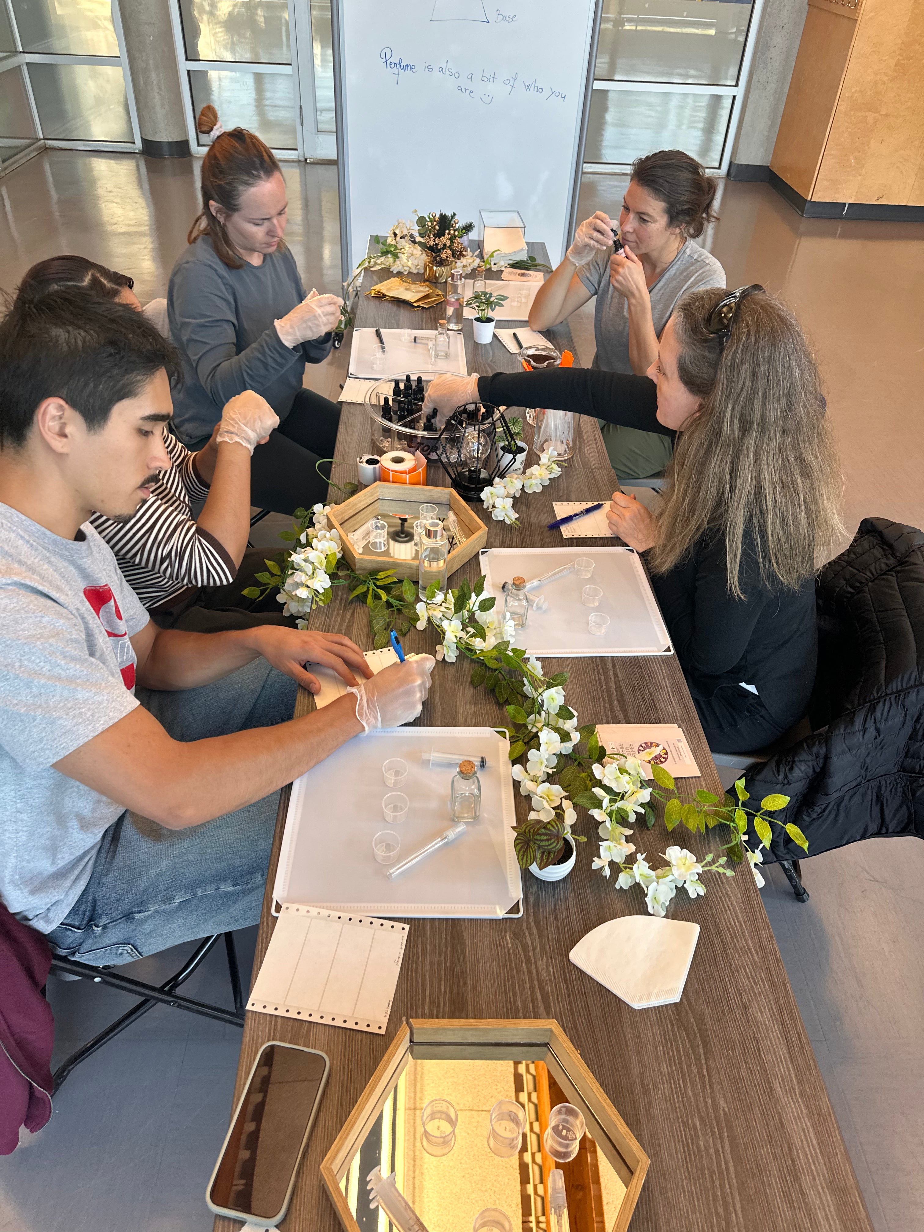 Perfume making class in Vancouver: a small group of adults smelling and noting natural scents at the ARTEI PHIRE studio